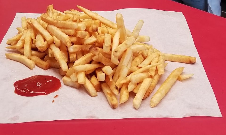 Menu board with burgers, fries, and shakes.